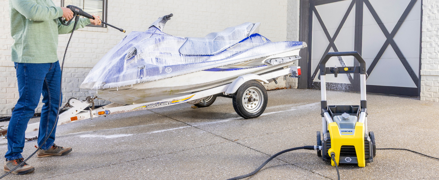 A person cleaning a jetski using a pressure washer