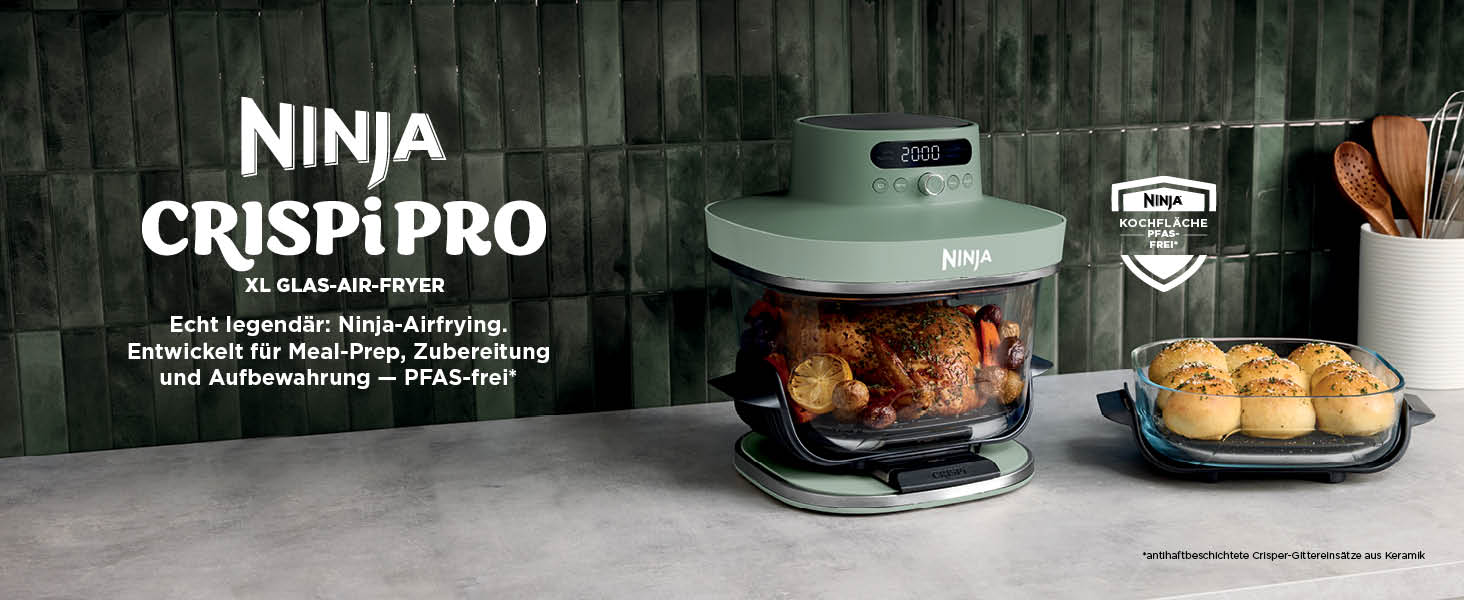El texto dice „NINJA CRISPI PRO“. Electrodoméstico de cocina con comida cocinada en su interior y en un plato cercano, sobre un fondo oscuro.